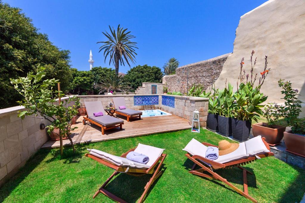 a backyard with two lawn chairs and a wooden deck at In Camera Art Boutique Hotel in Rhodes Town