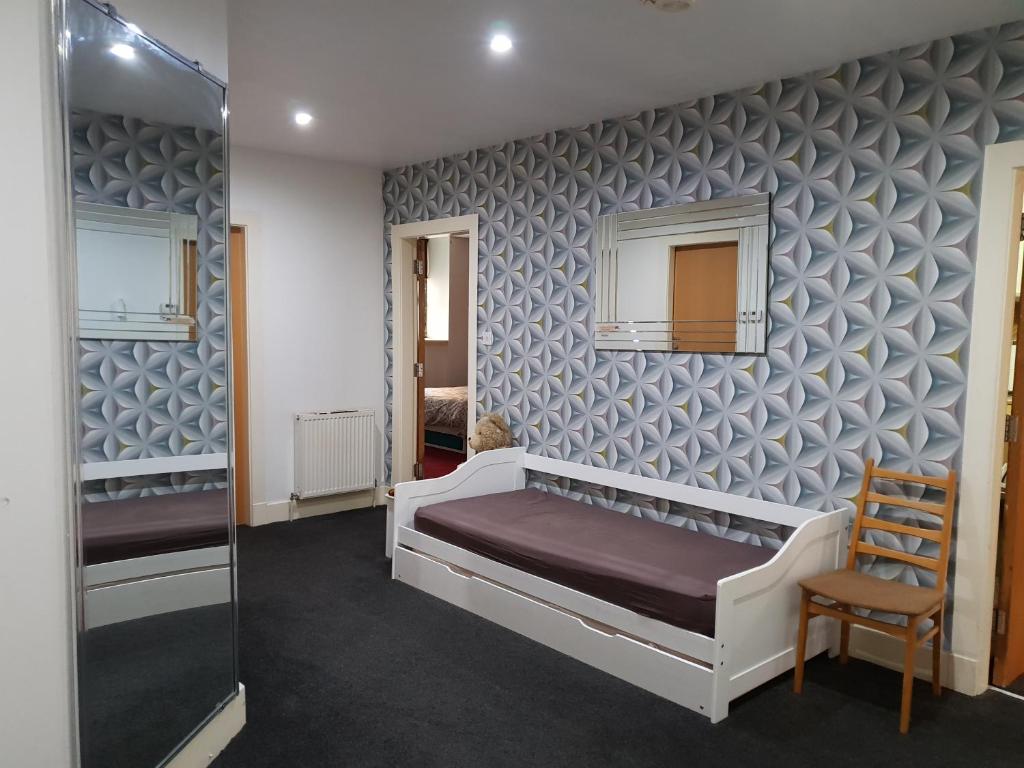 1 dormitorio con cama y pared con estampados en Perfect Stay Near Glasgow Town, en Glasgow
