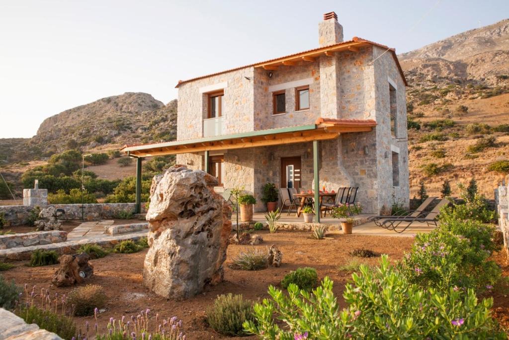 una casa de piedra con una roca delante de ella en Alexandros Villa, en Agia Paraskevi