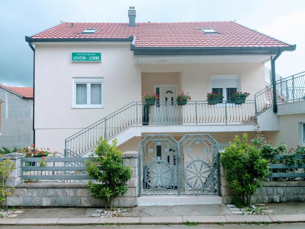 a house with a balcony and a gate at Apartments Lovori-Lorbe in Trebinje