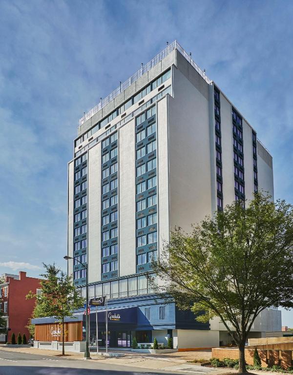 a tall white building with a tree in front of it at Graduate by Hilton Richmond in Richmond