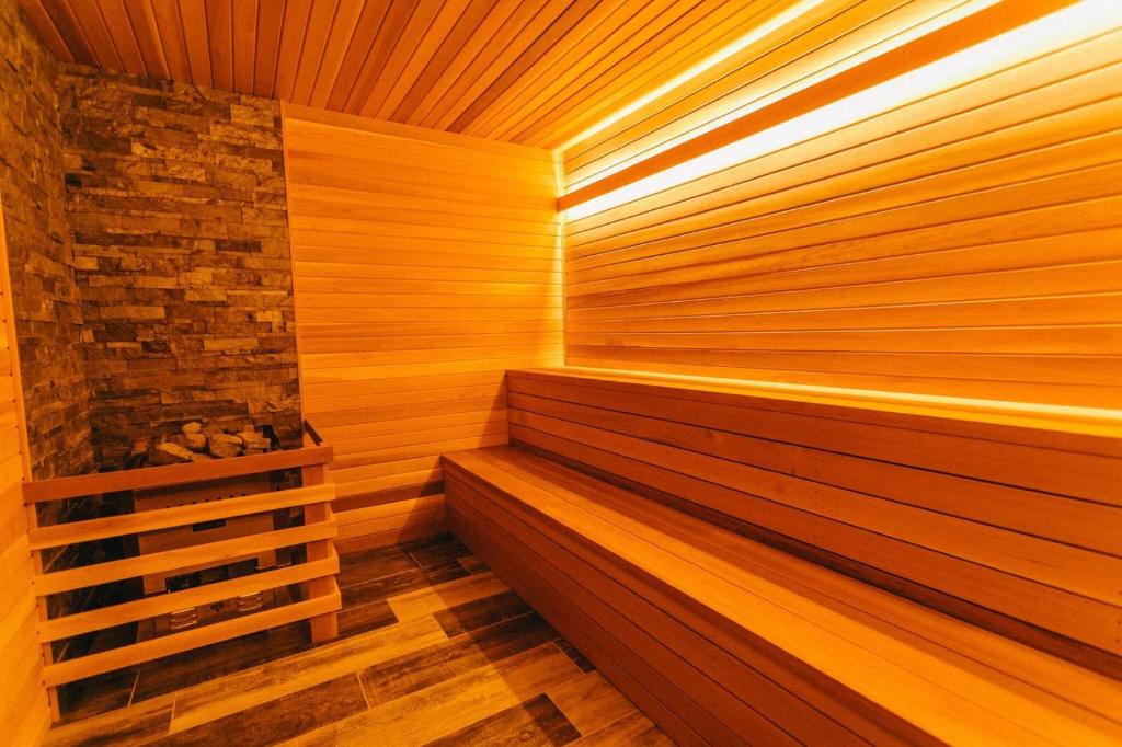 a wooden sauna with a stone wall at Basecamp Lodge Canmore in Canmore