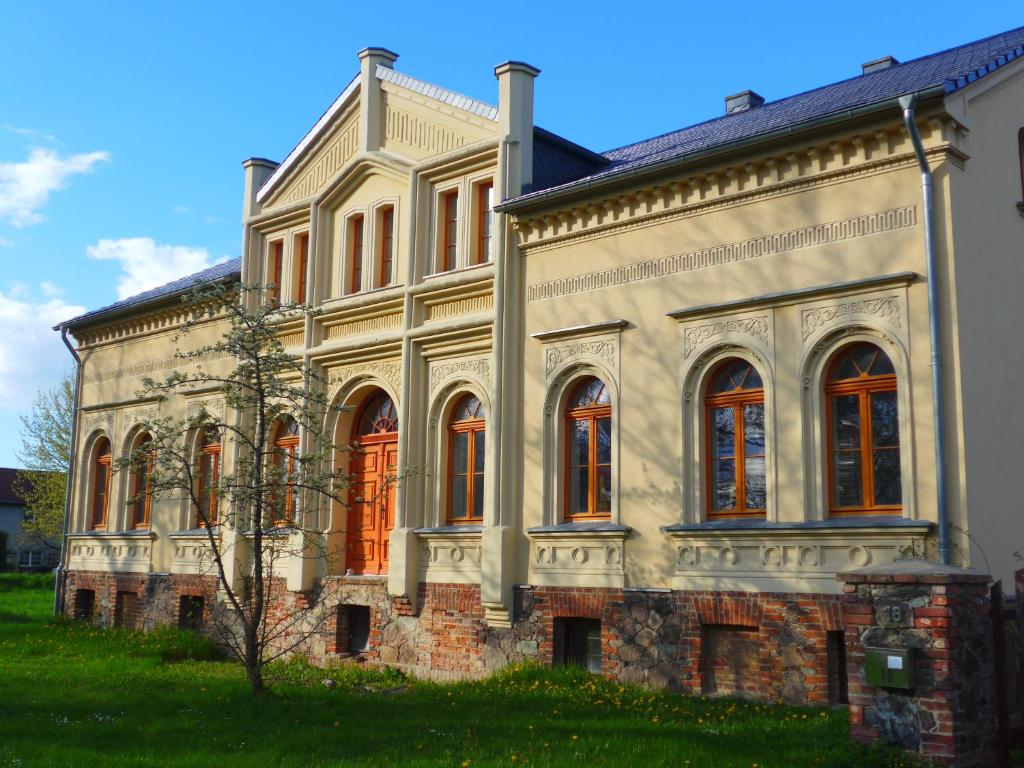 an old stone building with a tree in front of it at Ferienwohnung Pusteblume in Steinhöfel