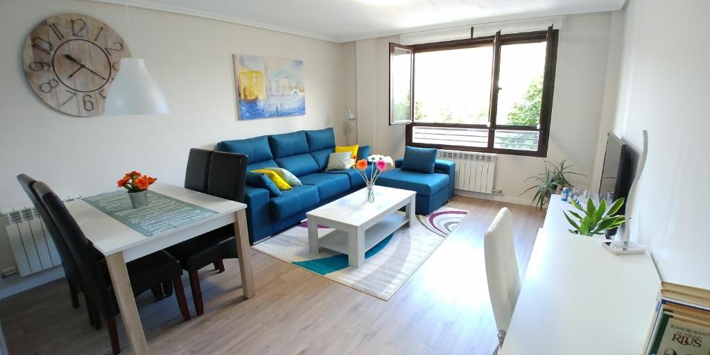 sala de estar con sofá azul y mesa en Apartamento ENTREVIÑAS en el corazón de La Rioja en Fuenmayor