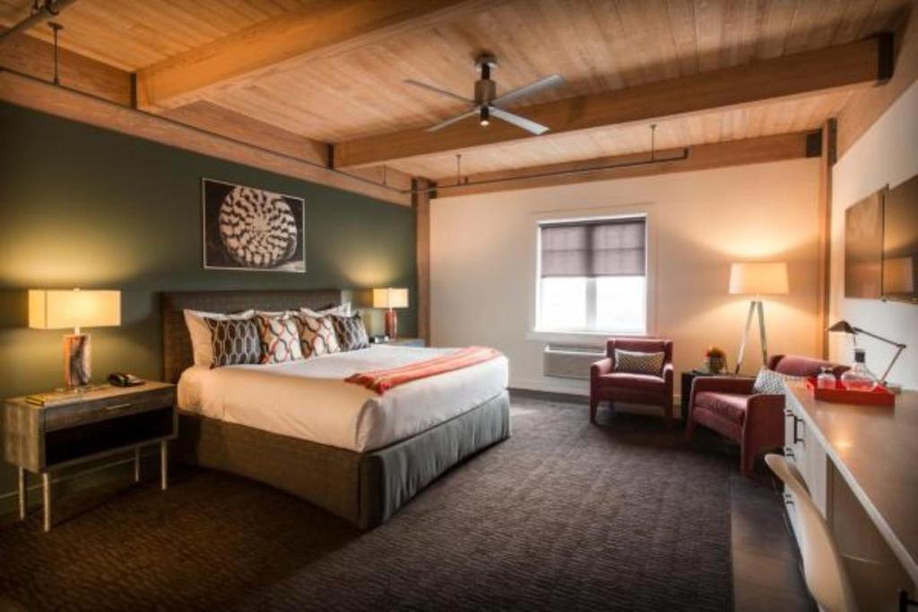 1 dormitorio con 1 cama, 1 silla y 1 ventana en Harbor House Hotel and Marina en Galveston