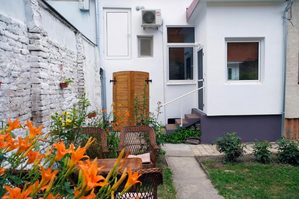 a garden with chairs and a table in front of a house at Oaza centar in Novi Sad