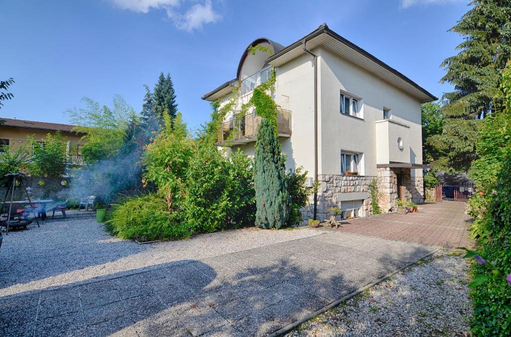 a house with a tree in front of it at Family Guesthouse GreenSLO in Ljubljana