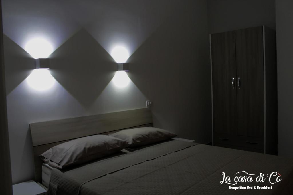 1 dormitorio con 1 cama con 2 luces en la pared en B&B La casa di Cò, en Nápoles