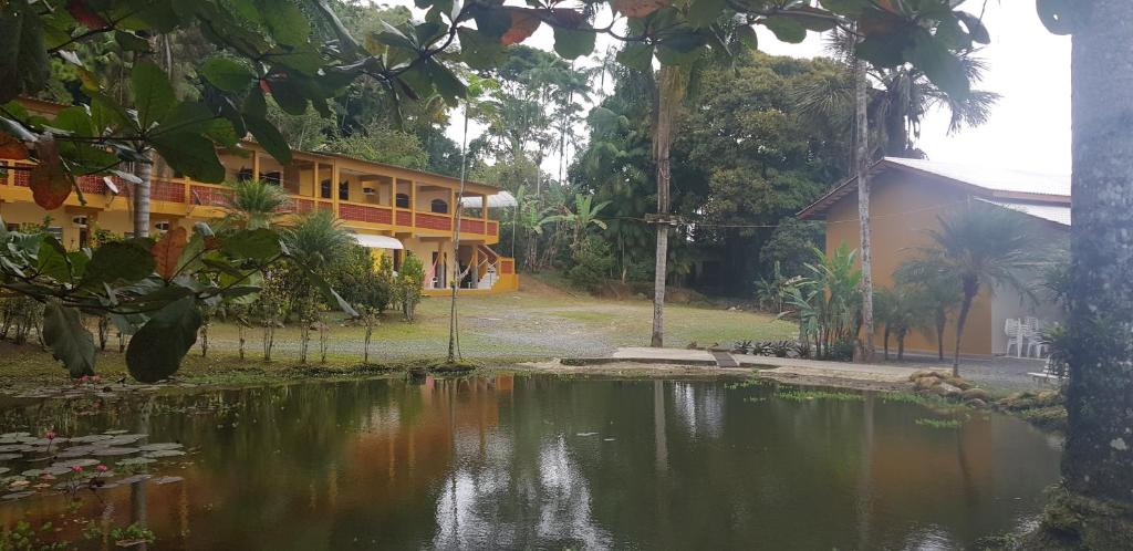 a house with a pond in front of a building at Pousada Recanto do Morro in Cananéia
