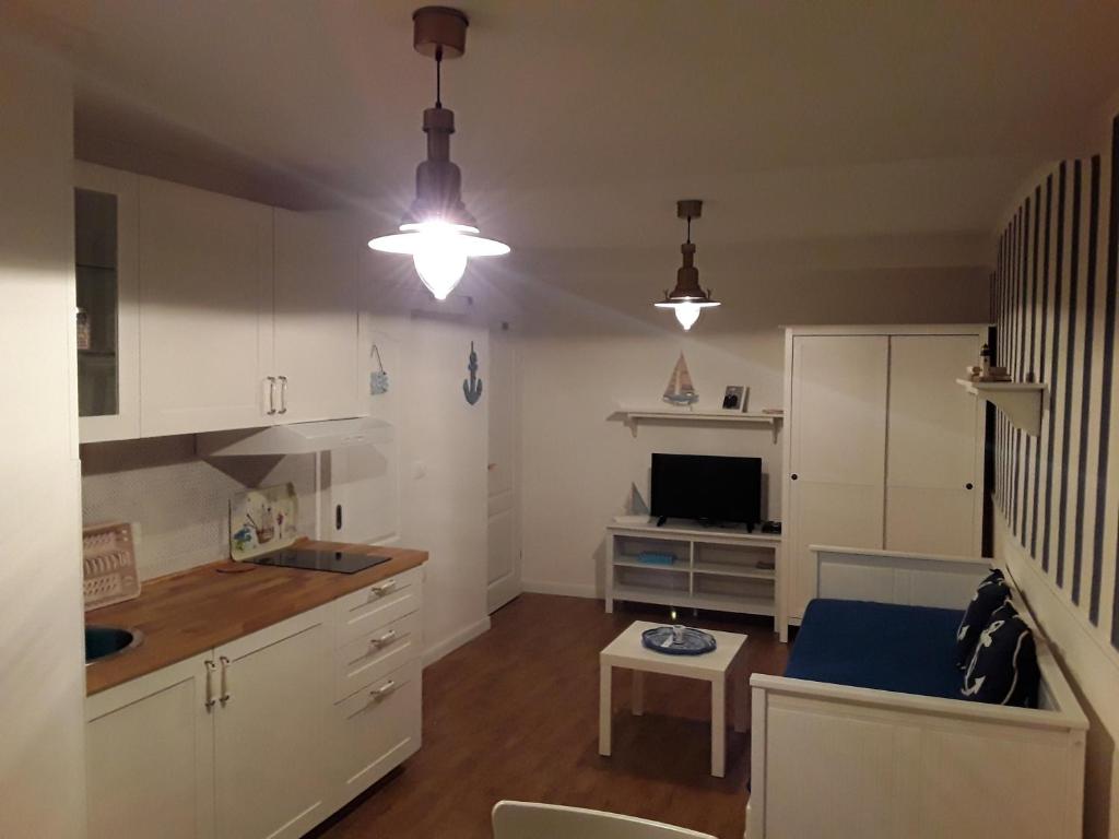 a kitchen with white cabinets and a table in a room at 3 Gracije in Koper