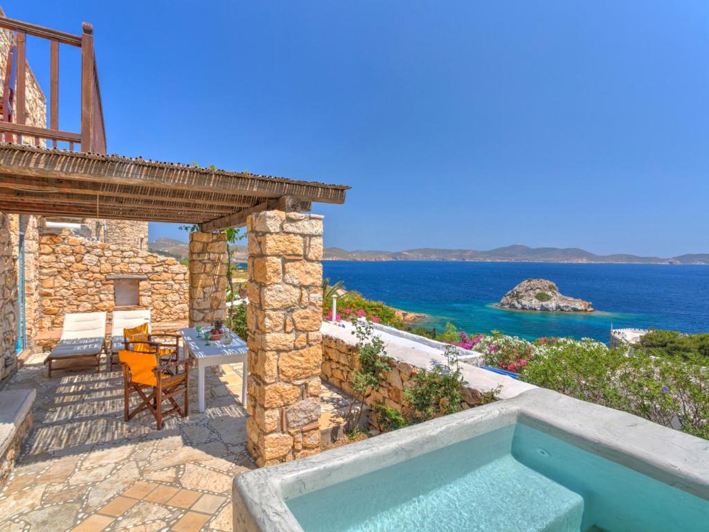 a villa with a swimming pool and a view of the ocean at Eirini Luxury Hotel Villas in Grikos