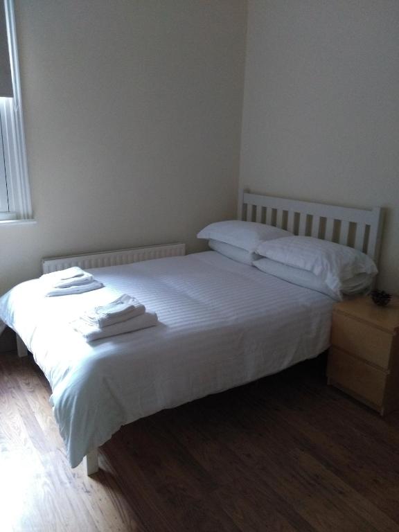 a bedroom with a white bed with towels on it at 64 Wardo Avenue in London
