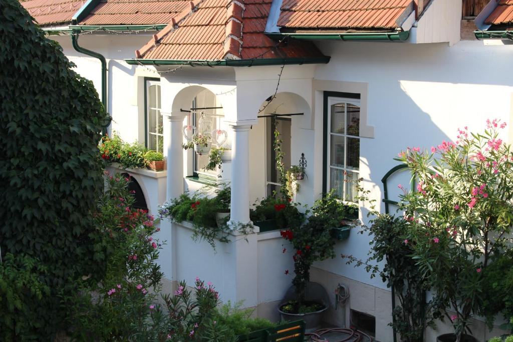 a white house with flowers and plants on it at Appartement "Blumengassl" in Mörbisch am See