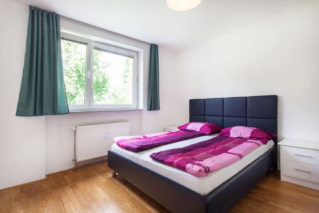 una camera da letto con un grande letto con lenzuola rosa di 70 square m with balcony+parking+AC a Lubiana