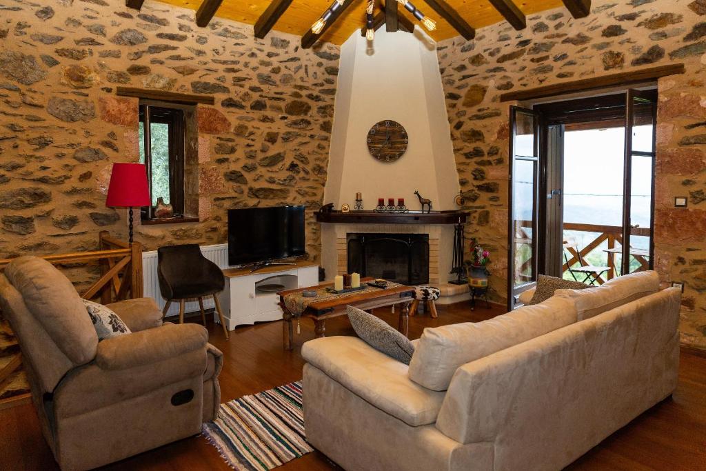 ein Wohnzimmer mit einem Sofa und einem Kamin in der Unterkunft Luxury House In The Hills in Sparta