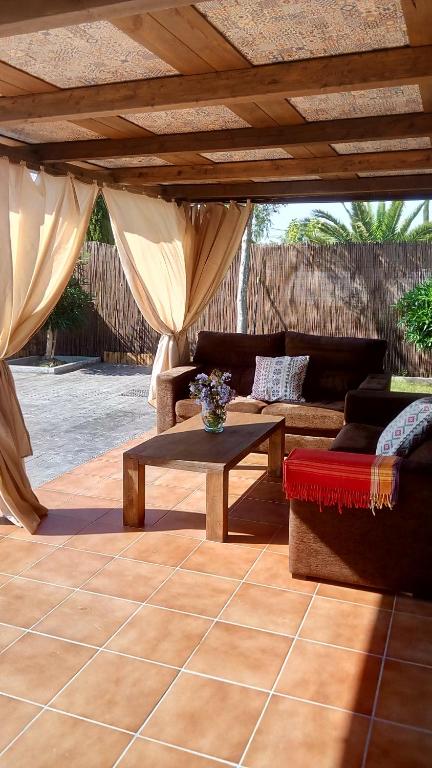 a patio with couches and a table under a roof at El vivero in Chiclana de la Frontera