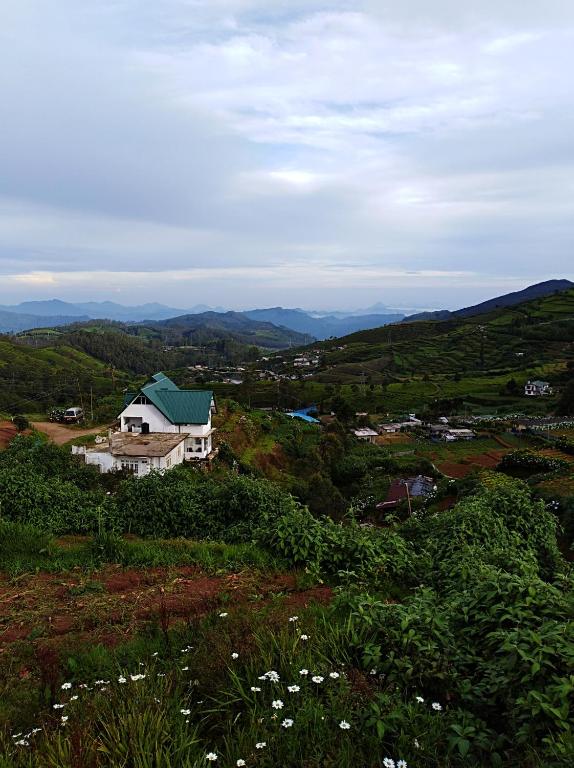 a house on a hill with mountains in the background at White house in Nuwara Eliya