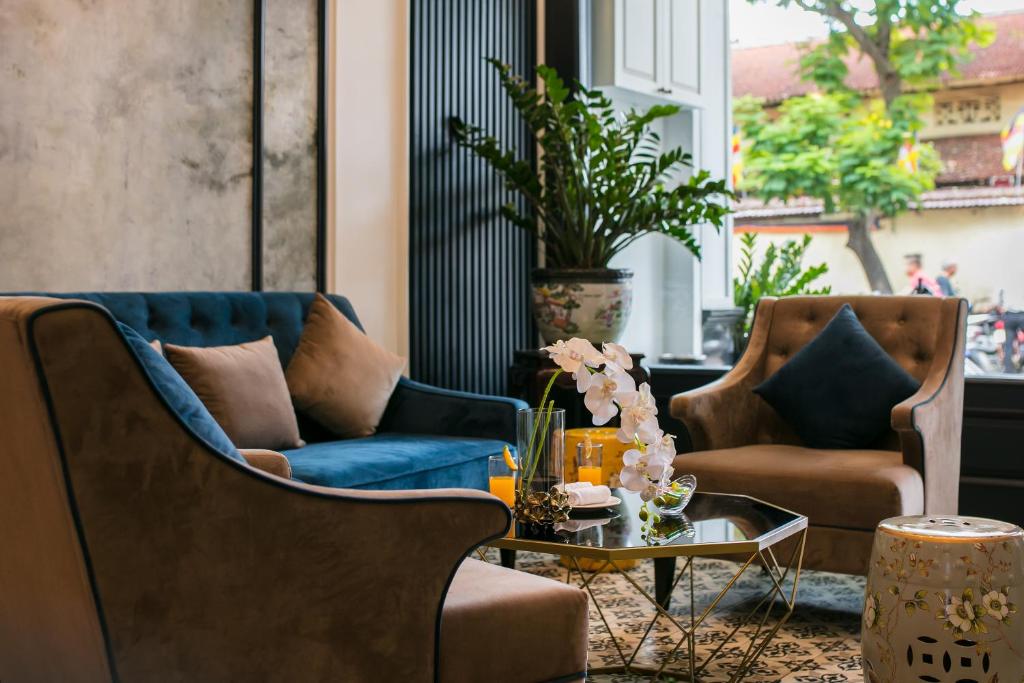 a living room with two chairs and a table at Golden Rooster Hotel in Hanoi