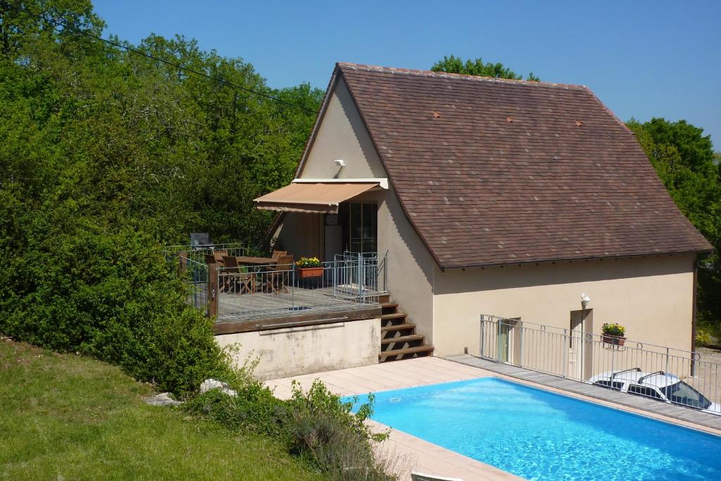 una casa con piscina di fronte a una casa di Les Menoyres a Loubressac