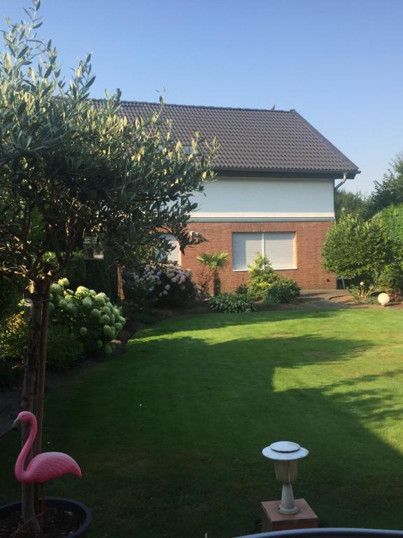 un patio con un flamenco rosa y una casa en Apartment am Park en Tönisvorst