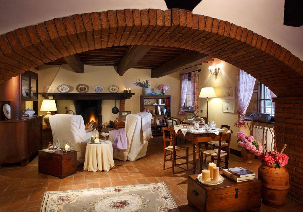 a living room with a table and chairs and a fireplace at Salvia e Rosmarino in Camaiore