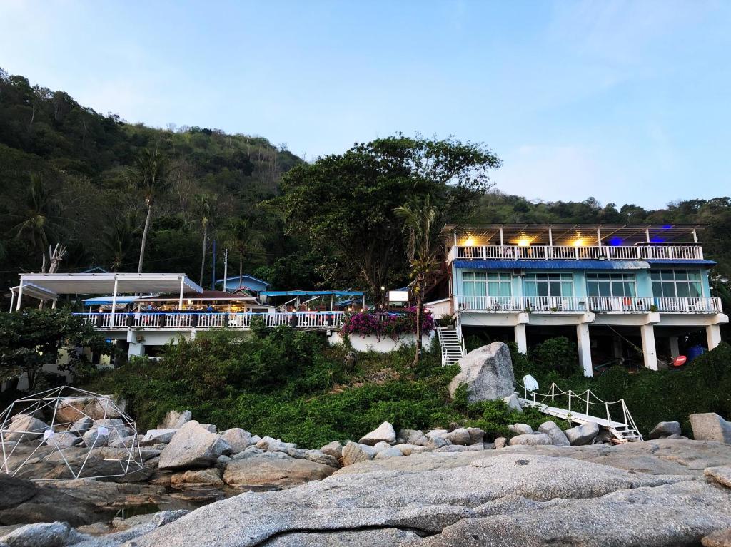 a large blue building with a balcony on a hill at Naiharn On The Rock Resort Phuket in Nai Harn Beach