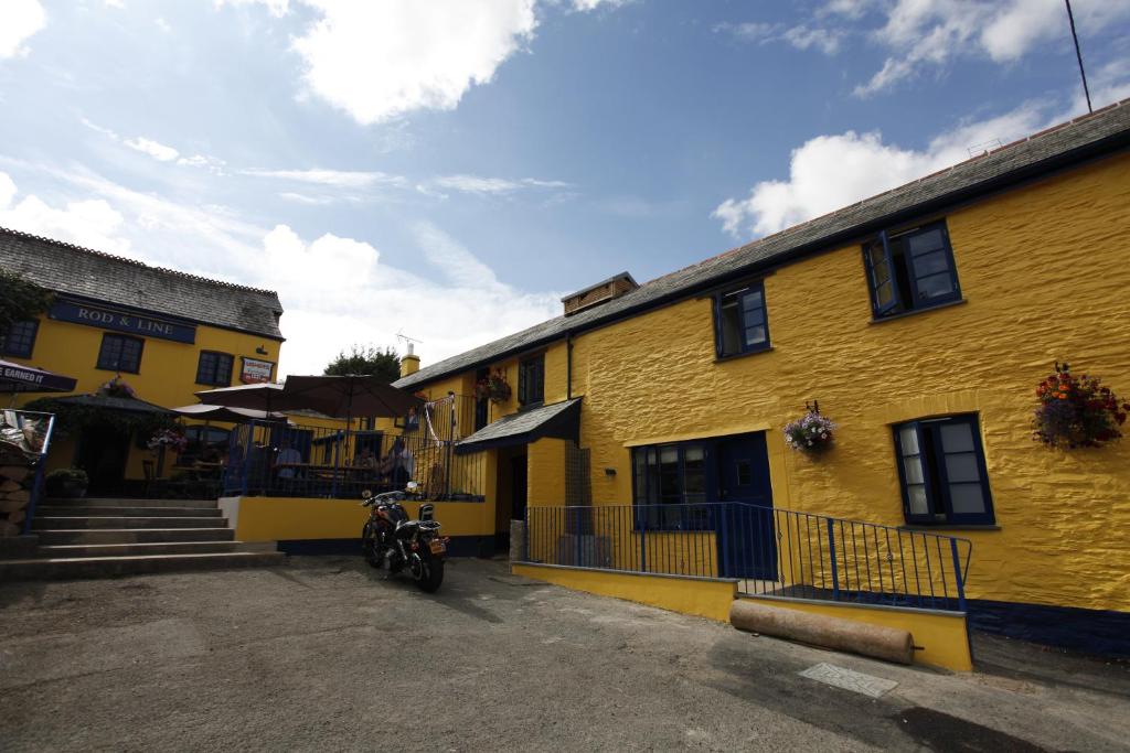 a motorcycle parked in front of a yellow building at Rod and Line in Landrake