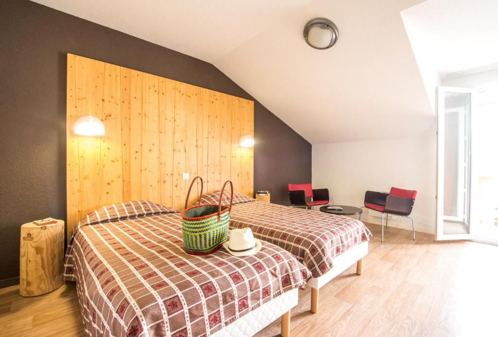 Village club de Bois d'Amont في Bois-dʼAmont: غرفة نوم بسريرين وكراسي حمراء