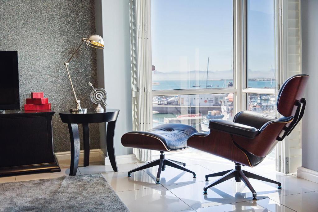 a living room with a chair and a desk and a window at 512 The Granger in Cape Town