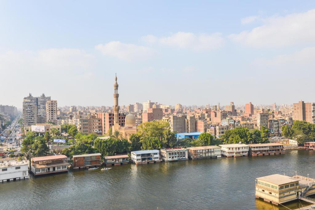 a river with houses and buildings in a city at Golden Tulip Hotel Flamenco Cairo in Cairo