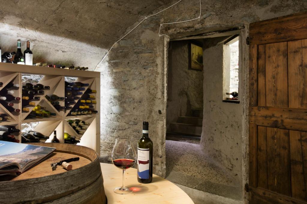 a bottle of wine sitting on a table with a glass at Hotel Tremoggia in Chiesa in Valmalenco