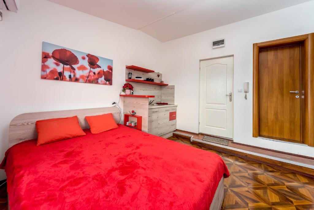una camera da letto con un letto rosso con una coperta rossa di Lux Apartment in Downtown a Belgrado
