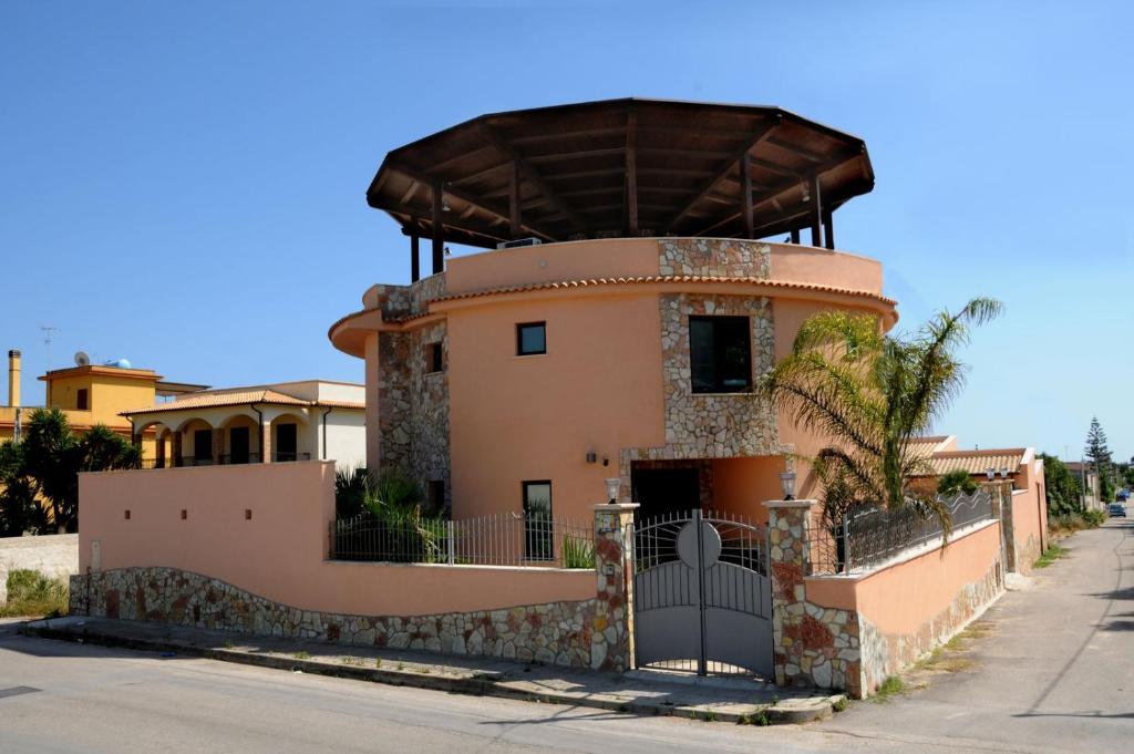 a large building with a clock on the side of it at Residence La Torre Del Sole in Mazara del Vallo