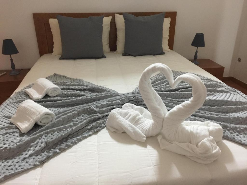 a white towel laying on top of a white bed at Invicta House Avenida da Boavista in Porto