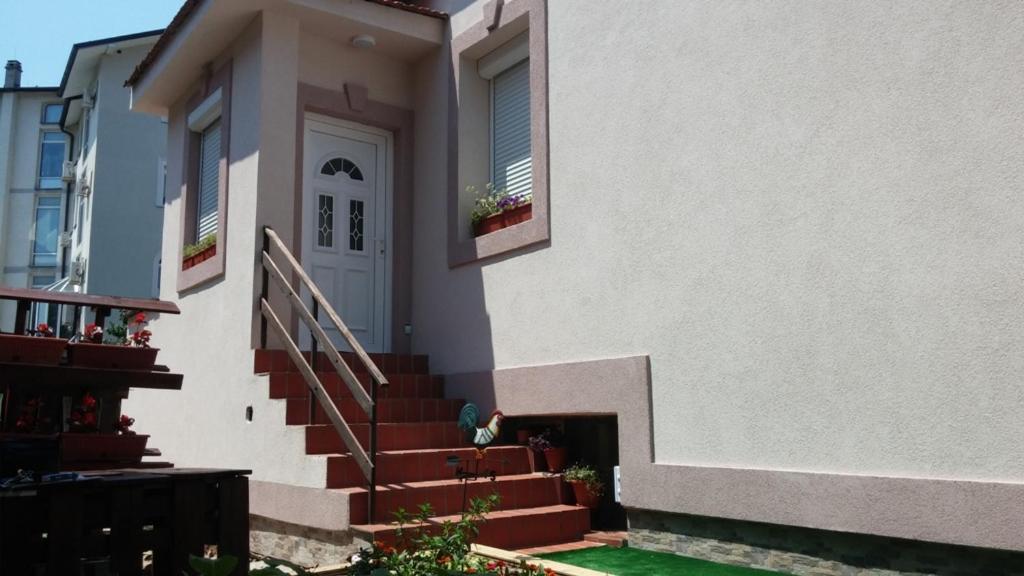 尼什的住宿－Kuća Popović Apartments，白色的房子,有楼梯通往门