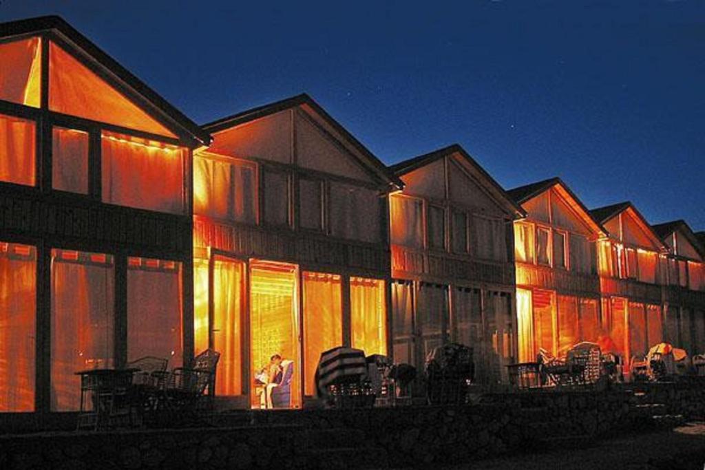 a person sitting in front of a building with lights at Nuweiba Lodge in Nuweiba