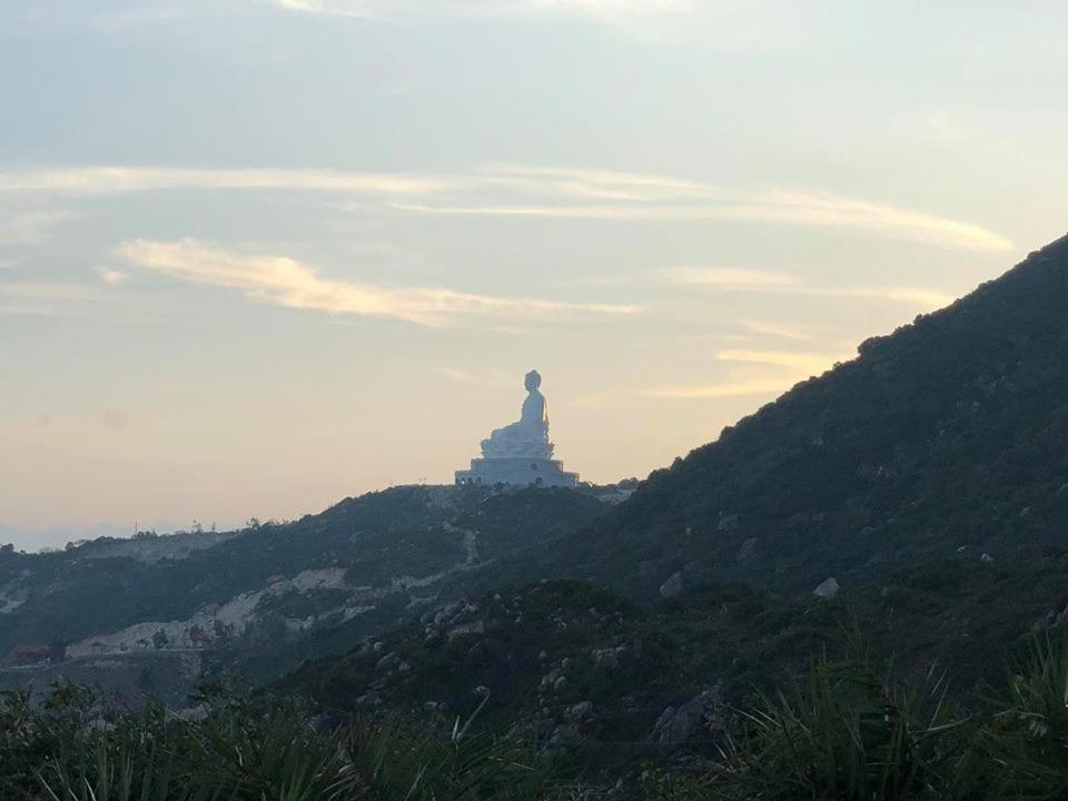 Nhon Ly Homestay في كوي نون: تمثال يجلس على قمة تل مع غروب الشمس