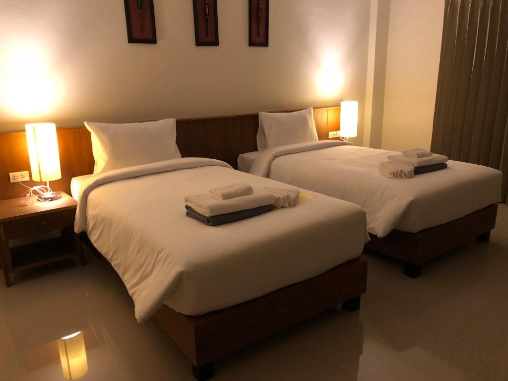 two beds in a hotel room with two lamps at Crystal Lamai Hotel in Lamai