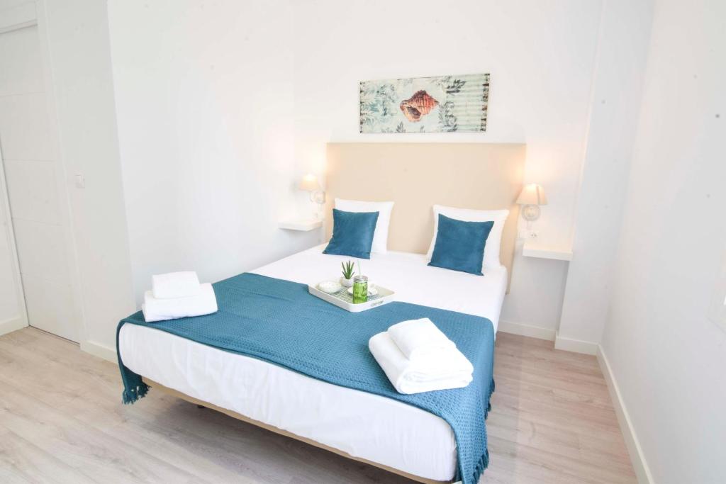 a bedroom with a bed with blue and white furniture at Letmalaga Andalucia in Málaga