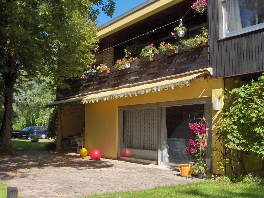 ein gelbes Haus mit einem Balkon mit Blumen darauf in der Unterkunft Villa Caroline in Pirmasens