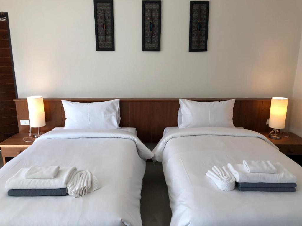 two beds in a room with white towels on them at Crystal Lamai Hotel in Lamai