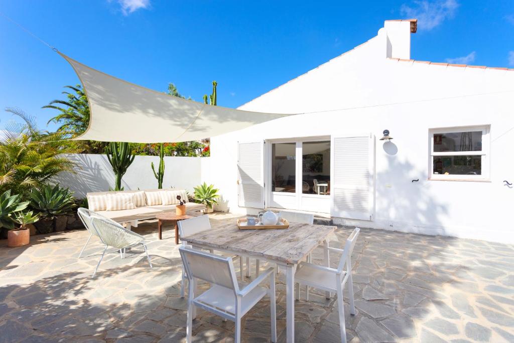 un patio con mesa de madera y sillas en Casita 3, Caserio de Guaza en Palm-mar