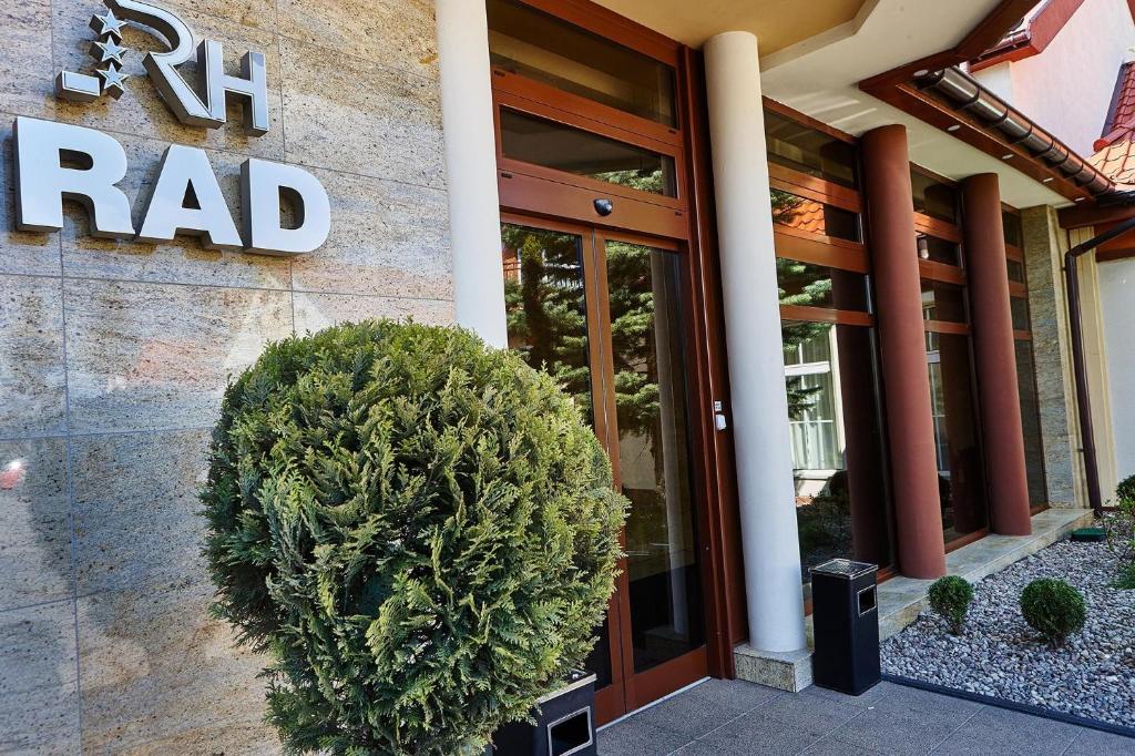 un edificio con un gran arbusto delante de él en Hotel Rad, en Grudziądz