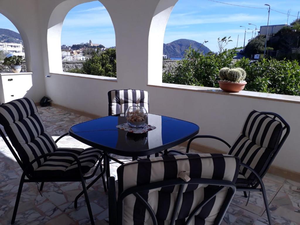 a table and chairs on a balcony with two windows at Casa Sabrina in Lipari