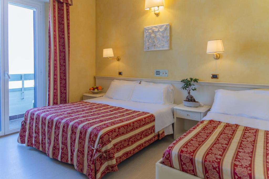 a hotel room with two beds and a window at Hotel Executive La Fiorita in Rimini