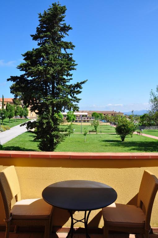 a table and chairs in a balcony with a tree at Poggio all'Agnello Sport & Family Holidays in Populonia