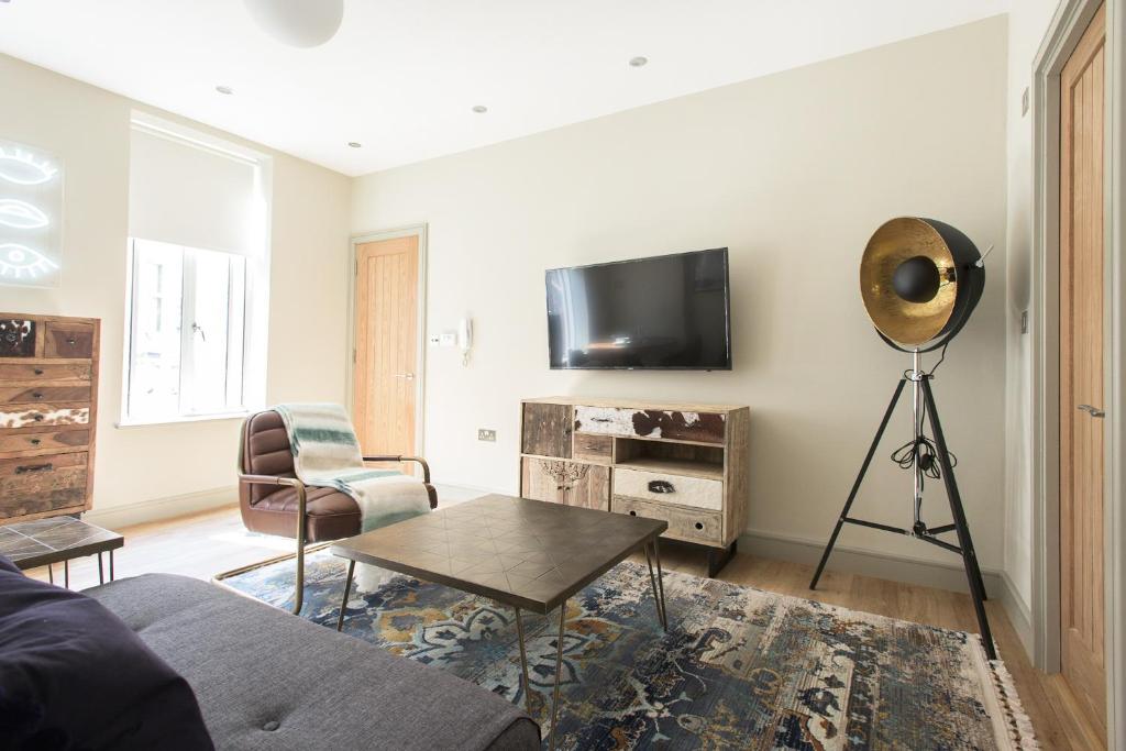 a living room with a flat screen tv on a wall at The Mayfair Parade - Trendy 1BDR in London