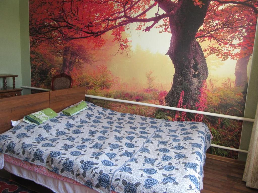 um quarto com uma grande pintura de uma árvore em "Bilim" Guest House em Tamchy
