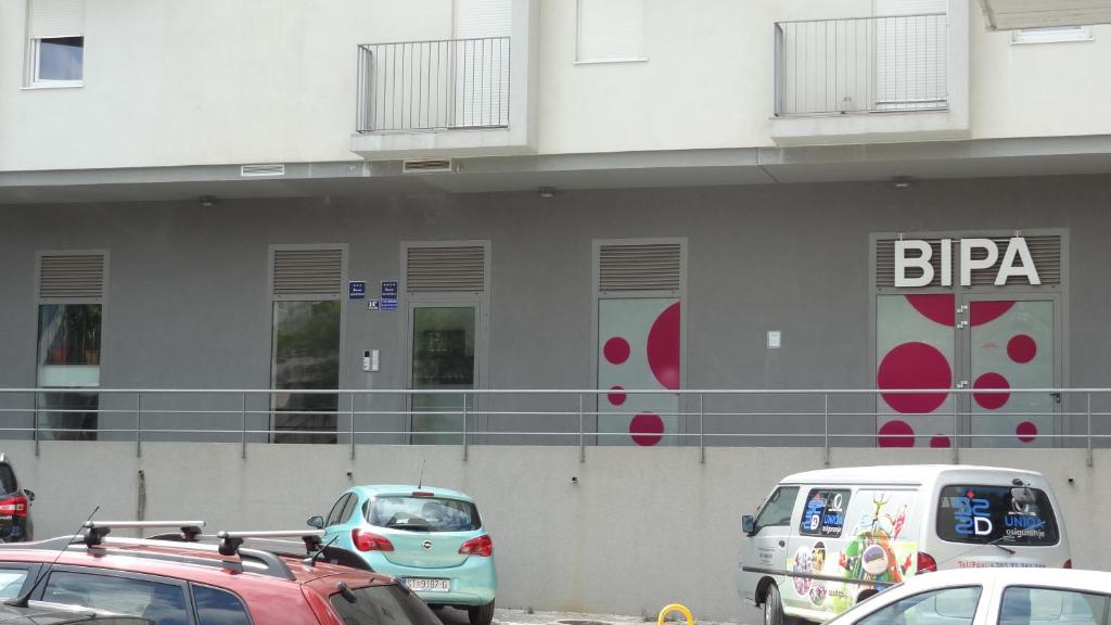 a parking lot with cars parked in front of a building at Cvit Jadrana in Split