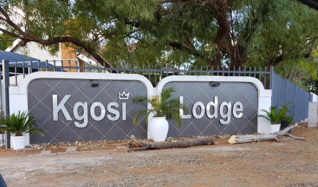 Una señal que dice kiegush y una valla en Kgosi Lodge, en Kimberley